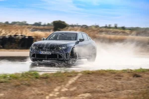 Camouflaged 2027 BMW M350 xDrive prototype undergoing performance testing on a proving ground track