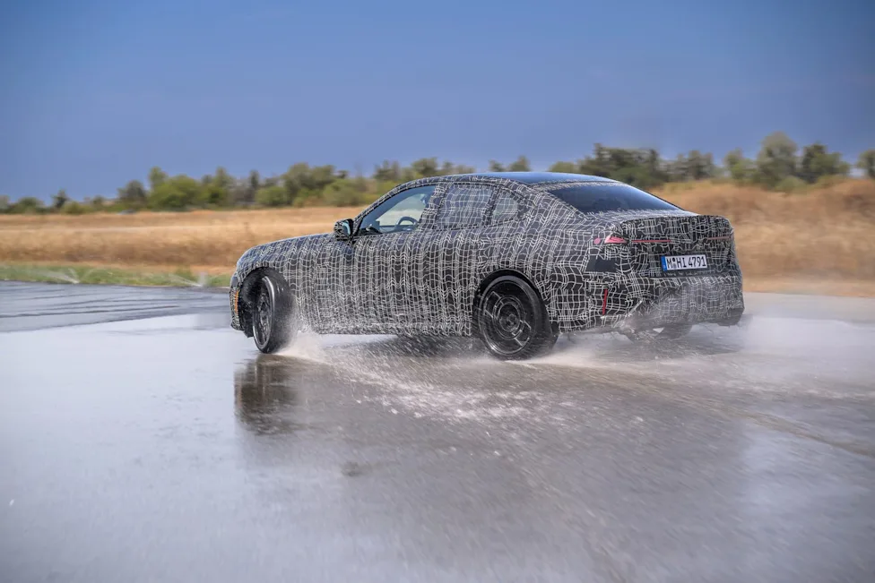Camouflaged 2027 BMW M350 xDrive prototype undergoing performance testing on a proving ground track
