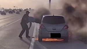 Corporal Joshua Swisher dragging a driver to safety from a burning car