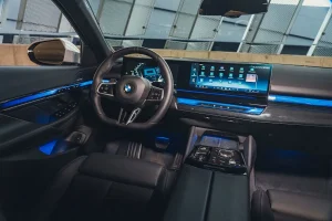 Interior view of the 2026 BMW 540i xDrive cabin featuring dashboard controls and ambient lighting