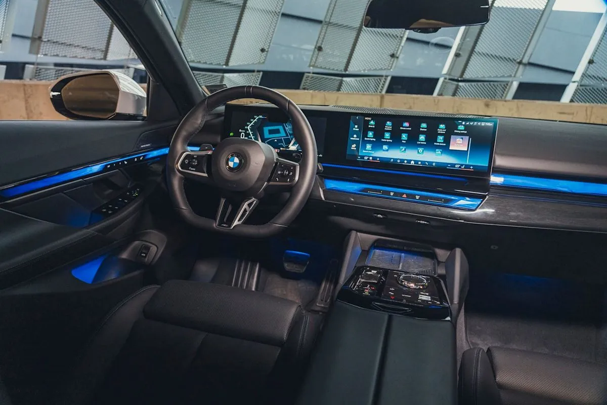 Interior view of the 2026 BMW 540i xDrive cabin featuring dashboard controls and ambient lighting