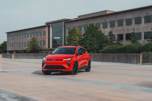 A red 2027 Chevrolet Bolt RS electric hatchback parked on an open road
