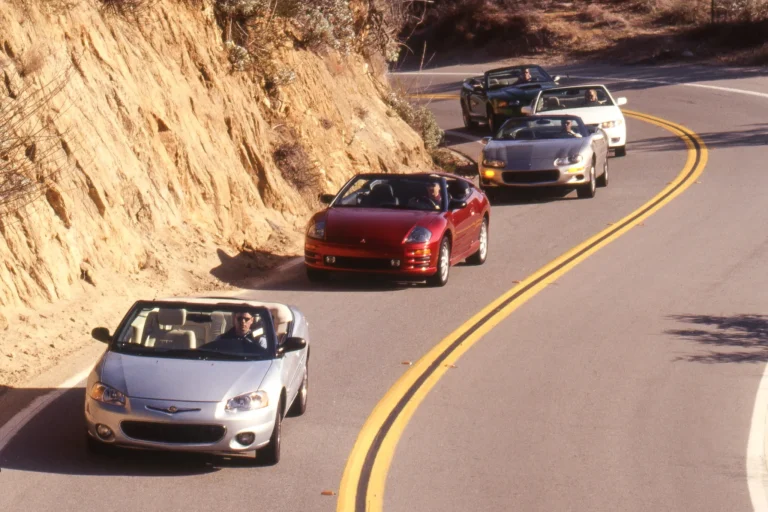 Vintage 2001 four-seat convertible cars lined up for a professional comparison test photo session.