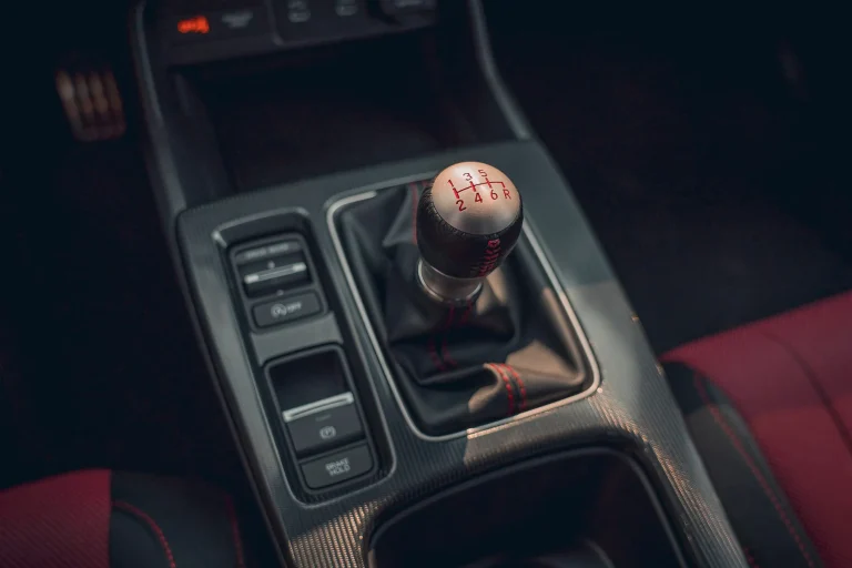 A manual gear shifter in a modern Honda Civic Si sport sedan