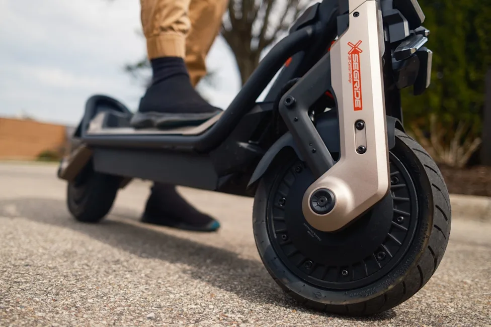 A variety of electric scooters parked on a paved surface during a product test