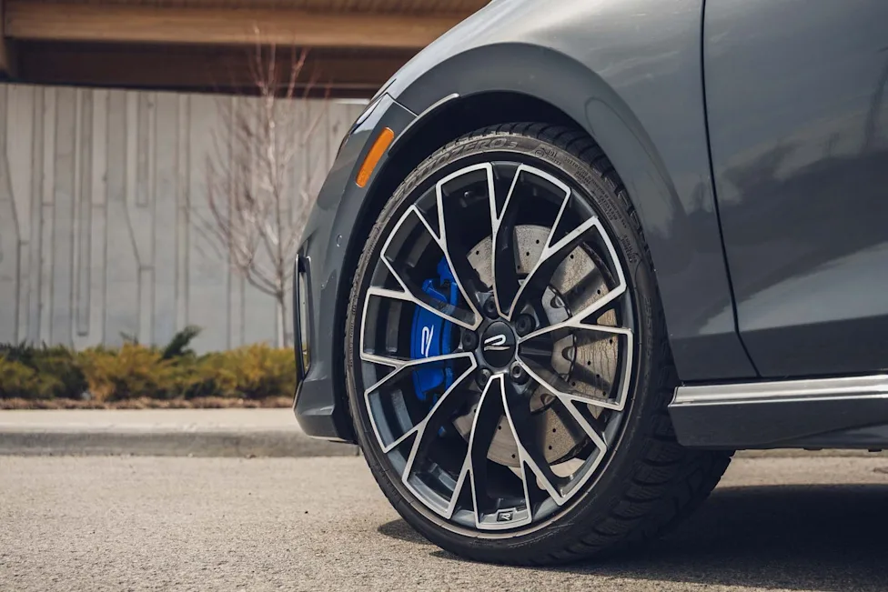 The 2026 VW Golf R parked near a racetrack showing its sleek design and forged wheels.