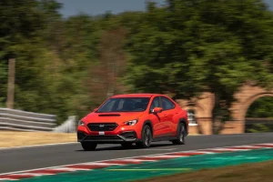 The front view of the red 2026 Subaru WRX on a race track