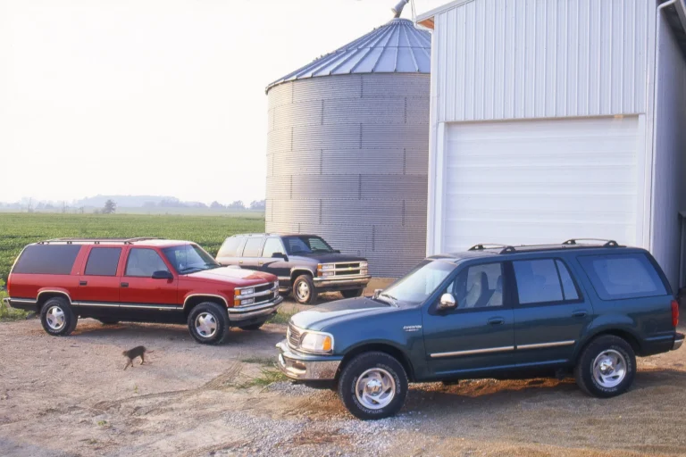 Three classic 1997 full-size American SUVs parked side-by-side during a comparison test