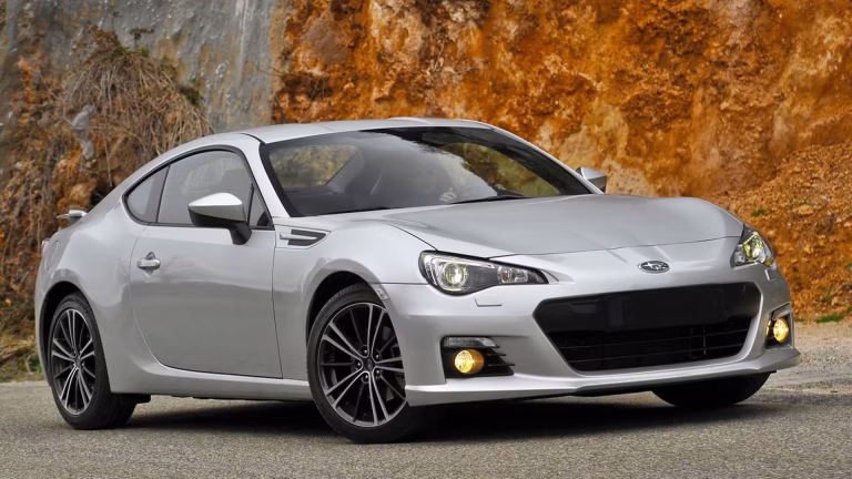 A modern Toyota GR86 sports car parked on an open road, highlighting its aerodynamic design and athletic stance
