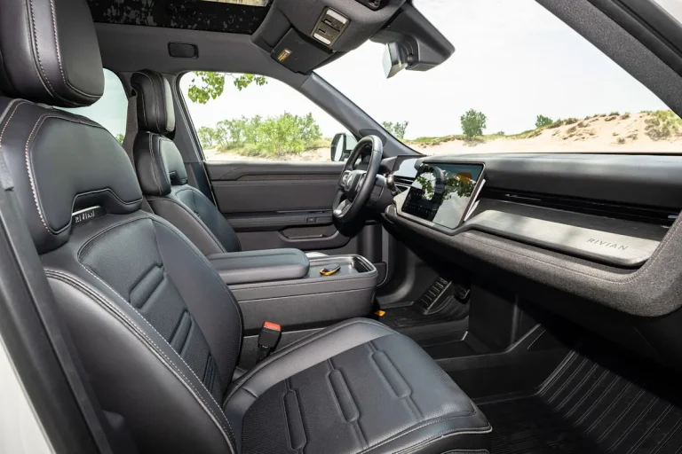 Interior cabin view of the 2026 Rivian R2 showing the dual dashboard screens and steering wheel